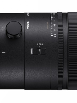 Close-up of a camera lens barrel showing focus ring, depth-of-field scale, and lock mechanism.