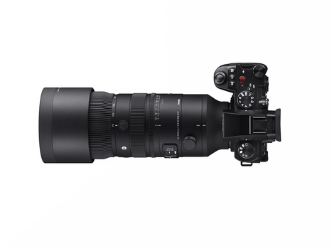 Mirrorless camera with telephoto lens mounted, viewed from above at three-quarter angle.