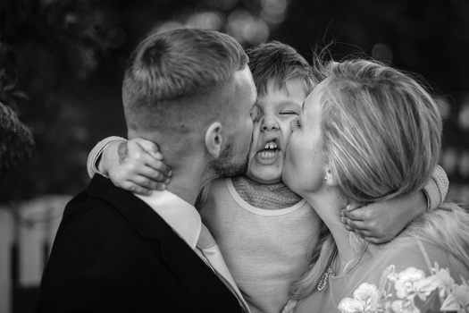 Three children embracing and smiling together in a candid moment.