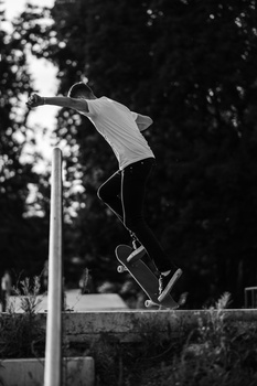 Skateboarder performing an aerial trick high above a concrete ledge in a skate park.