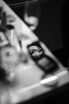 Close-up of a hand holding a camera with shallow depth of field in black and white.
