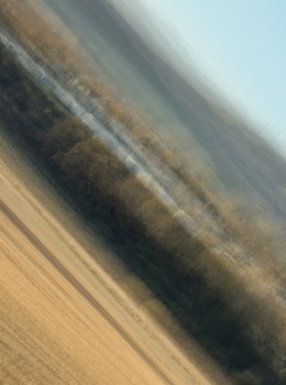 Diagonal motion blur of agricultural field with harvested and planted rows.