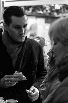 Two people in conversation outdoors, shot in black and white, with shallow depth of field.