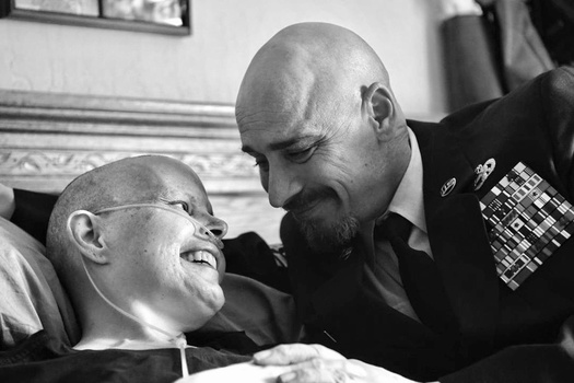 Two men in military uniforms sharing a warm moment, captured in black and white portrait photography.