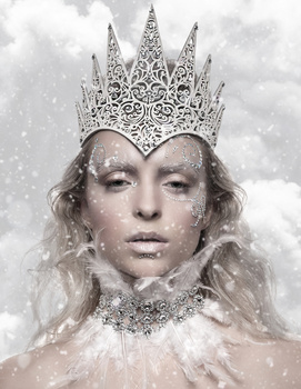 Person wearing ornate silver crown and embellished collar against snowy background.