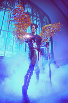 Figure with golden wings and glowing orbs in purple-blue lit environment with architectural backdrop.