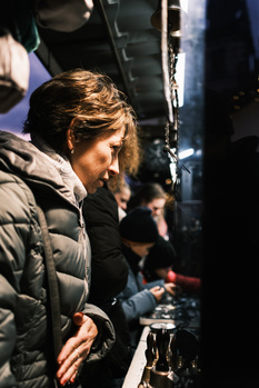Female cinematographer operating a camera on a film set at night.
