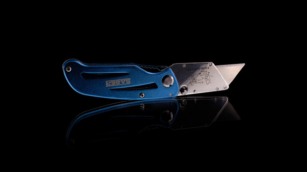 Blue folding utility knife with stainless steel blade against black background.