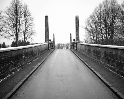 Symmetrical view down a pedestrian bridge with tall support pillars receding toward the horizon.