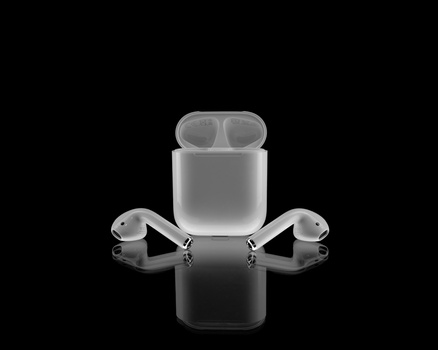 Wireless earbuds with charging case arranged symmetrically on a reflective black surface.