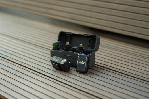 DJI drone with remote controller on wooden deck surface.