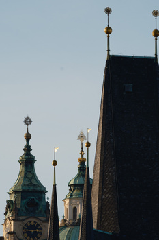 Ornate Orthodox church domes with golden crosses alongside a modern dark building against a clear sky.