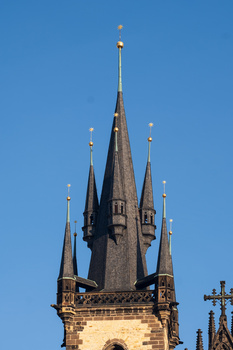 Gothic spire with multiple pointed towers against clear blue sky.