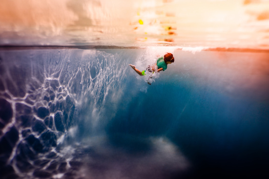 Snorkeler swimming near the water's surface with sunlight filtering through ripples.
