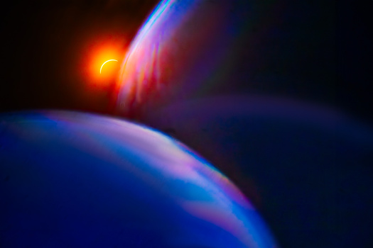 Luminous close-up of curved surfaces with warm golden light source and cool blue atmospheric lighting effects.