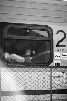 Child pressed against window of vintage television set in black and white photograph.