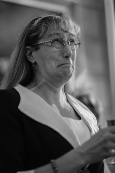 Woman wearing glasses and professional attire looking thoughtfully to the side in black and white portrait.