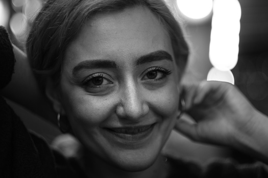 Black and white portrait of a young woman with short dark hair smiling at the camera.