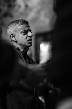 Middle-aged man in profile, shot in black and white with dramatic side lighting and dark background.