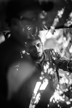 Black and white portrait of a man with bokeh lights creating depth of field effects around his face.