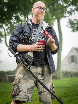 Man holding photography equipment outdoors in natural daylight.