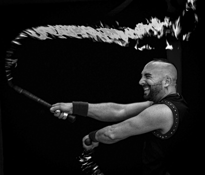 Man with battle ropes in dynamic athletic motion against black background.