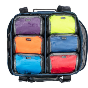 Organized packing cubes in six bright colors arranged in a dark backpack with mesh panels.