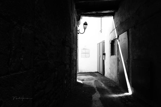 Dark tunnel with bright doorway at end and light streaming across floor.
