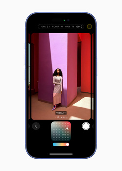 Screenshot of smartphone camera app showing portrait of woman in geometric interior with magenta and red walls.
