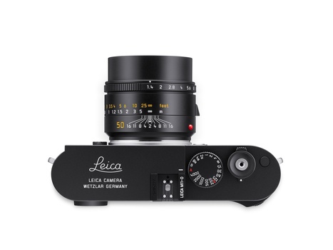 Top-down view of a Leica rangefinder camera with a 50mm lens mounted on black body.