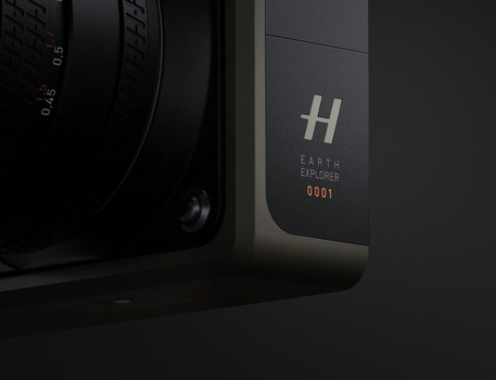 Close-up of a camera body showing an H logo and serial number 0001 on the back panel.