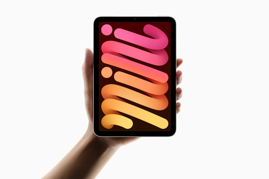 Hand holding tablet displaying vibrant gradient color palette from pink to yellow.