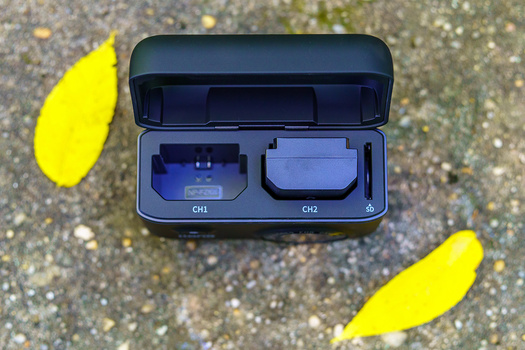 Open case displaying two compact camera lens filters labeled CH1 and CH2, surrounded by yellow leaves on pavement.