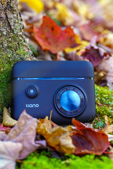 Ueno thermal imaging camera positioned on moss-covered surface with autumn leaves in soft focus background.