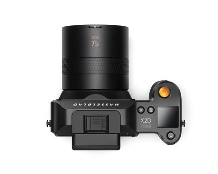 Top-down view of a compact mirrorless camera with an attached 75mm lens and articulating rear screen.