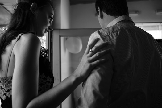 Woman touching man's shoulder in black and white intimate portrait.