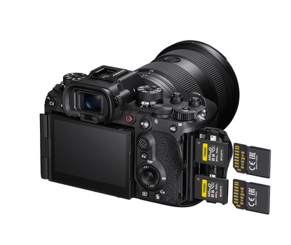 Professional mirrorless camera with attached lens and four XQD memory cards displayed beside it.