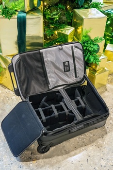 Open rolling camera case with customizable foam insert compartments and dividers for equipment storage.