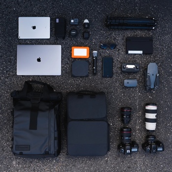 Flat lay of photography and creative equipment arranged on a textured dark surface.