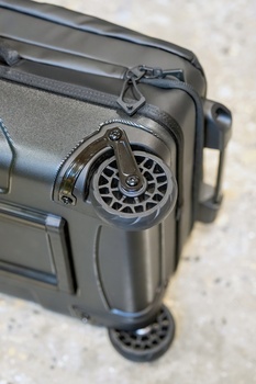Close-up of a compact camera's retractable lens mechanism extended, showing intricate mechanical details and gear system.