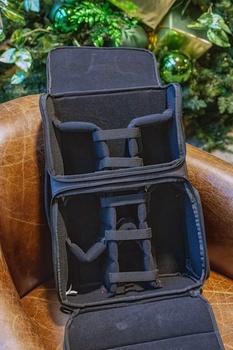 Open camera gear backpack with padded dividers and compartments displaying customizable storage layout.