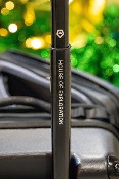 Bosch car battery terminal clamp with blurred green bokeh background and automotive cables.