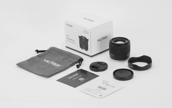 Viltrox lens with accessories laid out including box, pouch, lens caps, hood, and documentation.