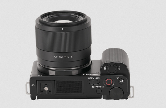 Sony mirrorless camera with AF 56/1.7 E lens mounted, viewed from above against white background.
