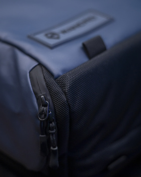 Close-up of a dark blue camera bag with a black zipper and fabric texture detail.