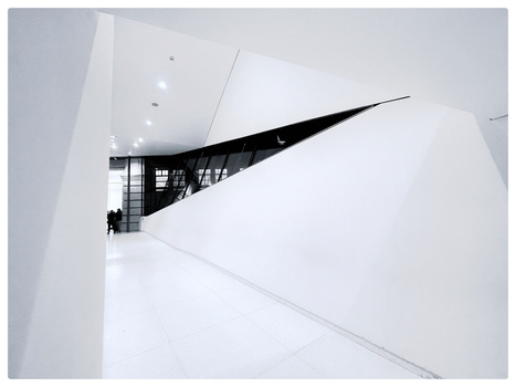 Minimalist interior staircase with sharp angular forms and high contrast black and white composition.