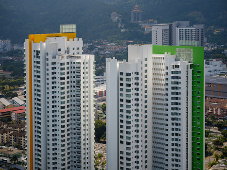 Colorful residential high-rises with yellow and green accent panels overlooking a sprawling cityscape.