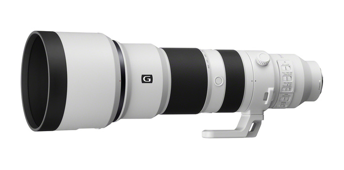 White and black telephoto lens with focus ring and depth-of-field scale markings.