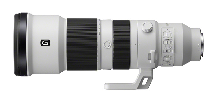 White and black telephoto lens with control rings and focusing mechanism mounted on white tripod collar.