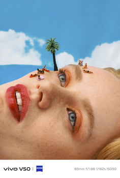 Surreal composite portrait with miniature landscape scene positioned on woman's face.